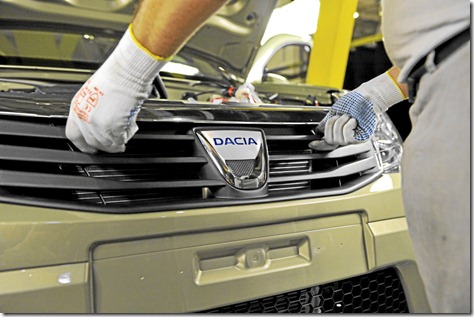 Mise en place du bouclier avant avec le logo Dacia.
Gand d'un ouvrier